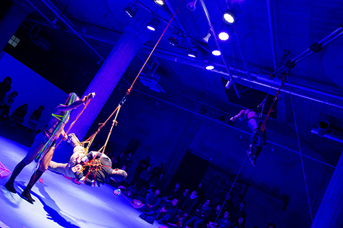 Luke George suspends a bound audience member in mid-air, while Kok too is being suspended high towards the ceiling by three audience members (not pictured). Photo:Hideto Maezawa.