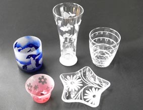 ガラスの器などにシールやビニールテープでデザインを作り、砂を当てて削り、模様をつけるサンドブラスト体験